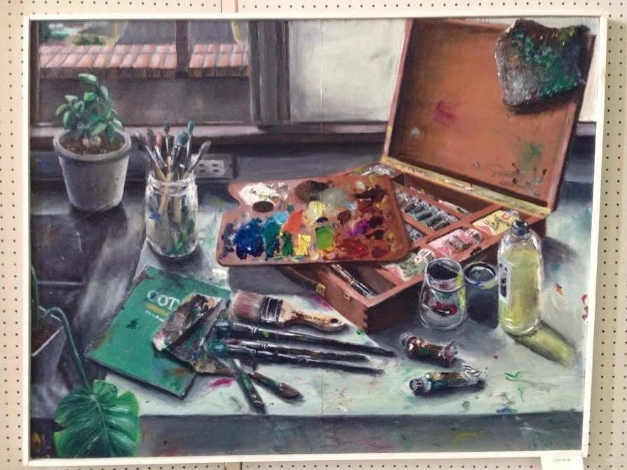 窓辺に置かれたパレット、絵の具、筆などの画材を描いた作品